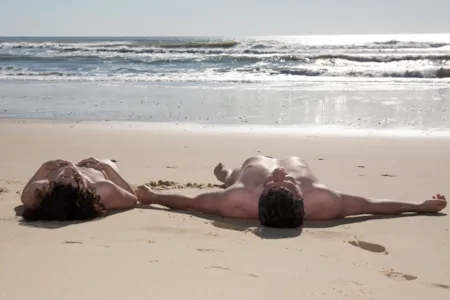 Liegendes Nudistenpaar am Strand