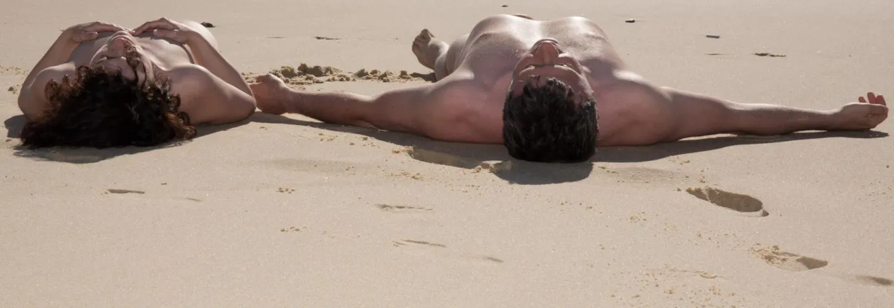 Liegendes Nudistenpaar am Strand