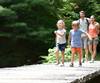 Glückliche Familie auf einem Holzsteg am See