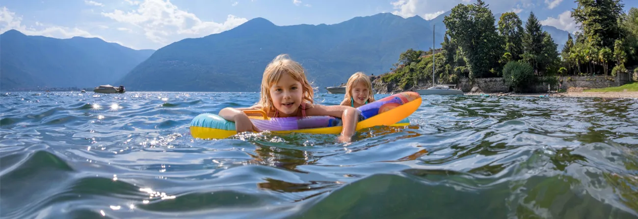 Zwillinge, die im See am Lago Maggiore in Italien schwimmen