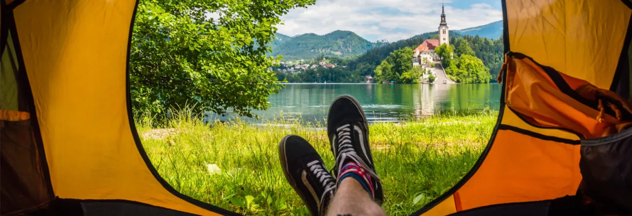 Sicht eines Campers aus dem geöffneten Zelt auf den Bleder See in Slowenien