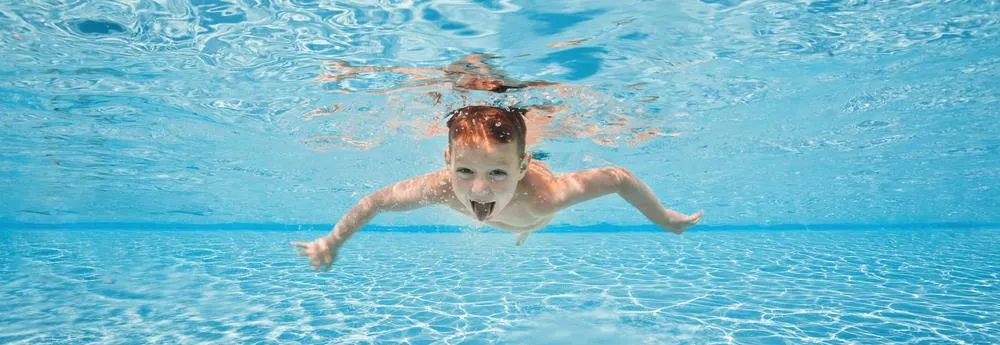 garçon nage sous l'eau et sort sa langue