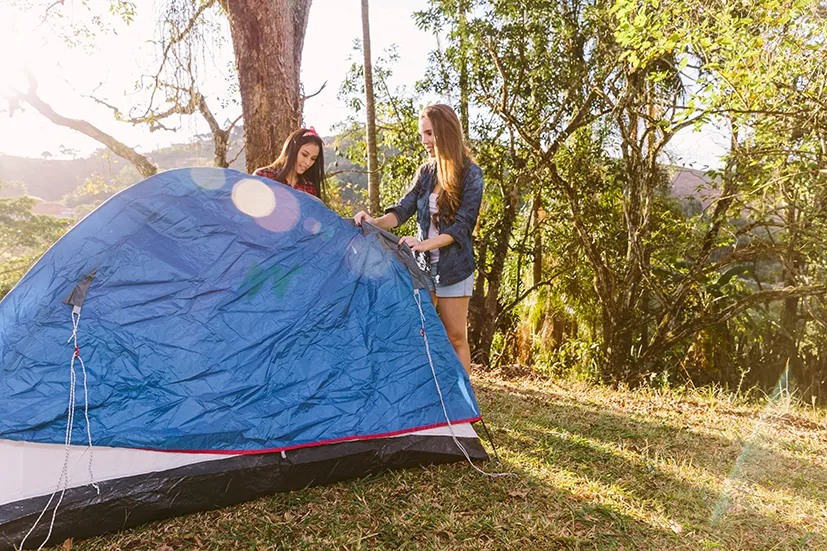 jeunes femmes montent tente camping