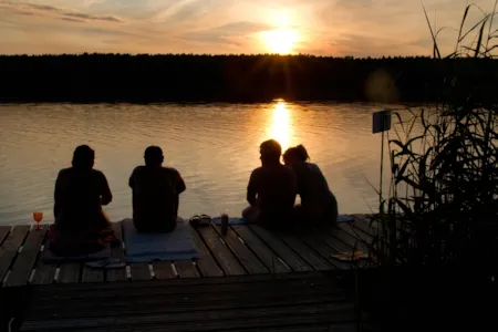Gruppe von Campinggästen beim Sonnenuntergang am Rätzsee