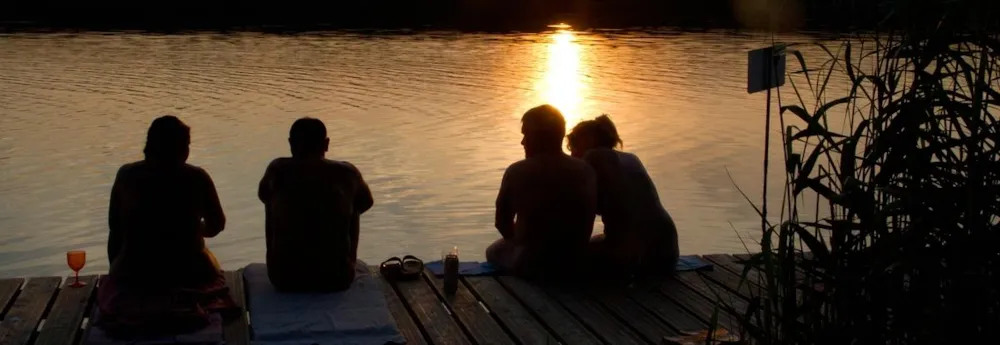 Gruppe von Campinggästen beim Sonnenuntergang am Rätzsee