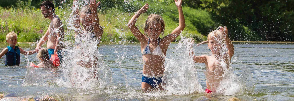 Kinder planschen in einem Fluss