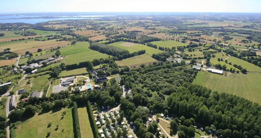 Blick von oben auf Campingplatz mit Meer am Horizont