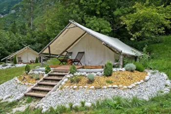 Glamping-Zelt umgeben von kleinem Steingarten mit Holzstufen