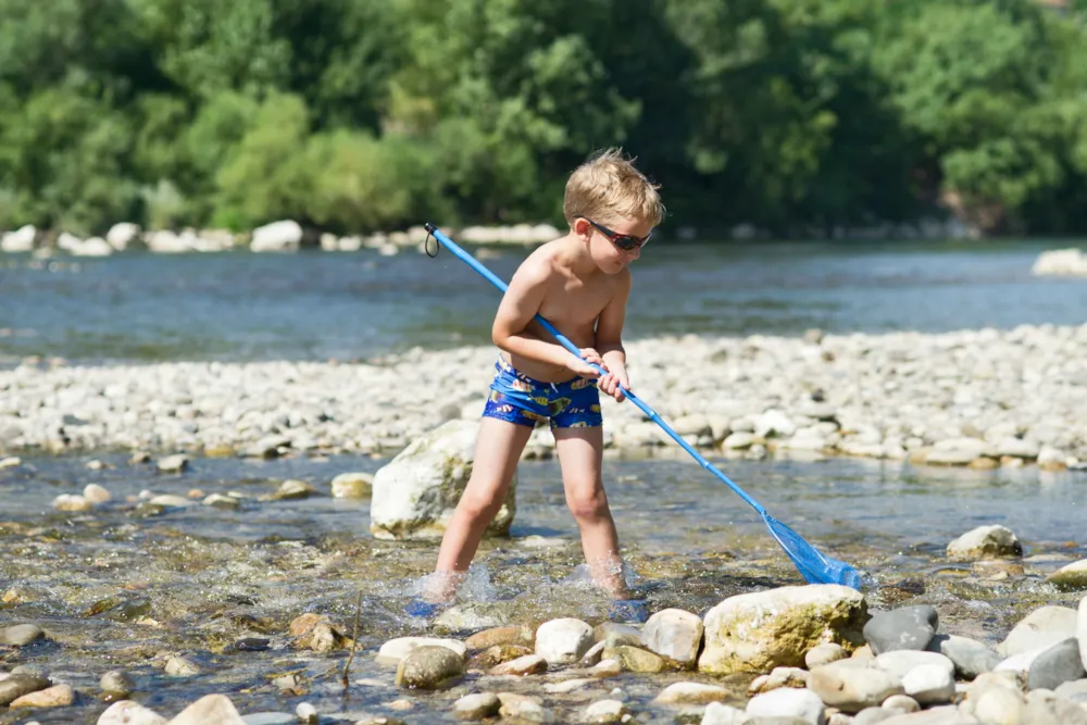 Junge mit Fangnetz am Fluss