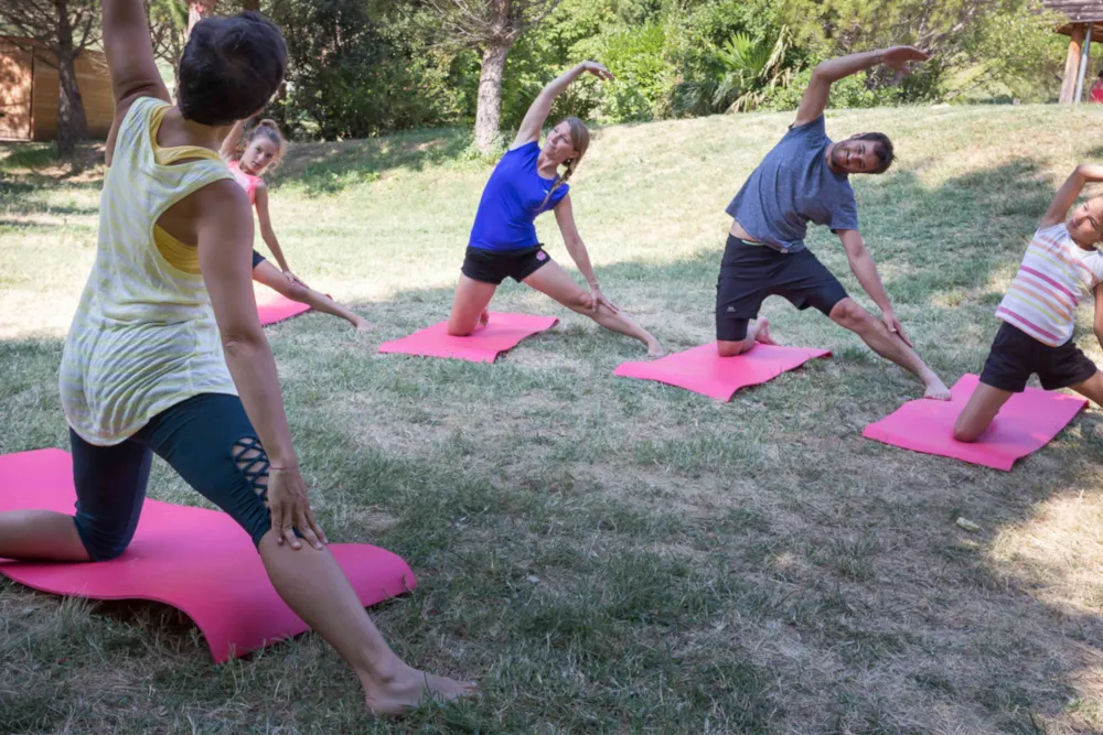 Gruppe von Campinggästen beim Yoga