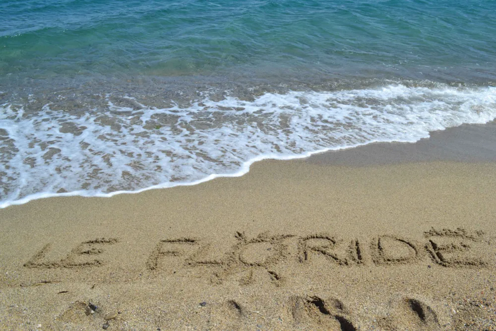 Camping-Schriftzug im Sand am Strand