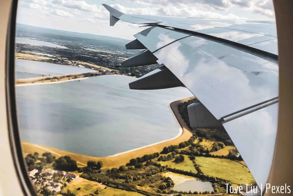 Blick aus Flugzeug auf Landschaft und Teil der FLugzeugtragfläche