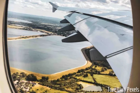 Blick aus Flugzeug auf Landschaft und Teil der FLugzeugtragfläche