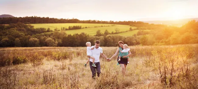 Glückliche Familie bei Spaziergang auf Feld in Natur