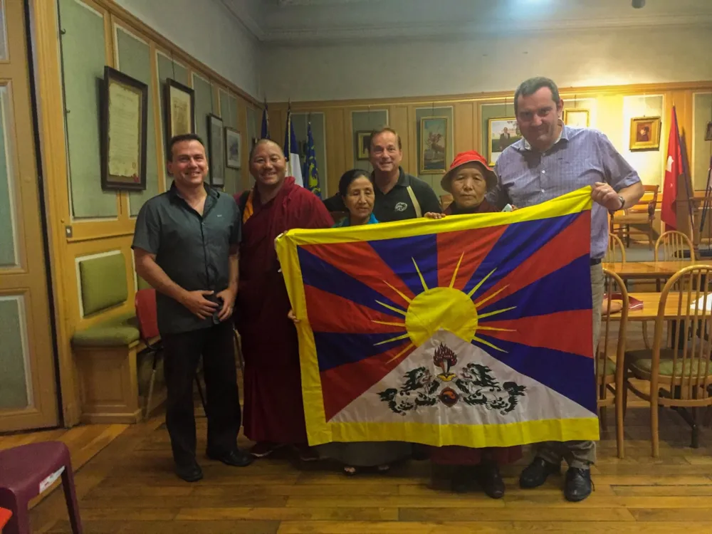 Gruppenfoto mit Mönch und tibetanischer Flagge