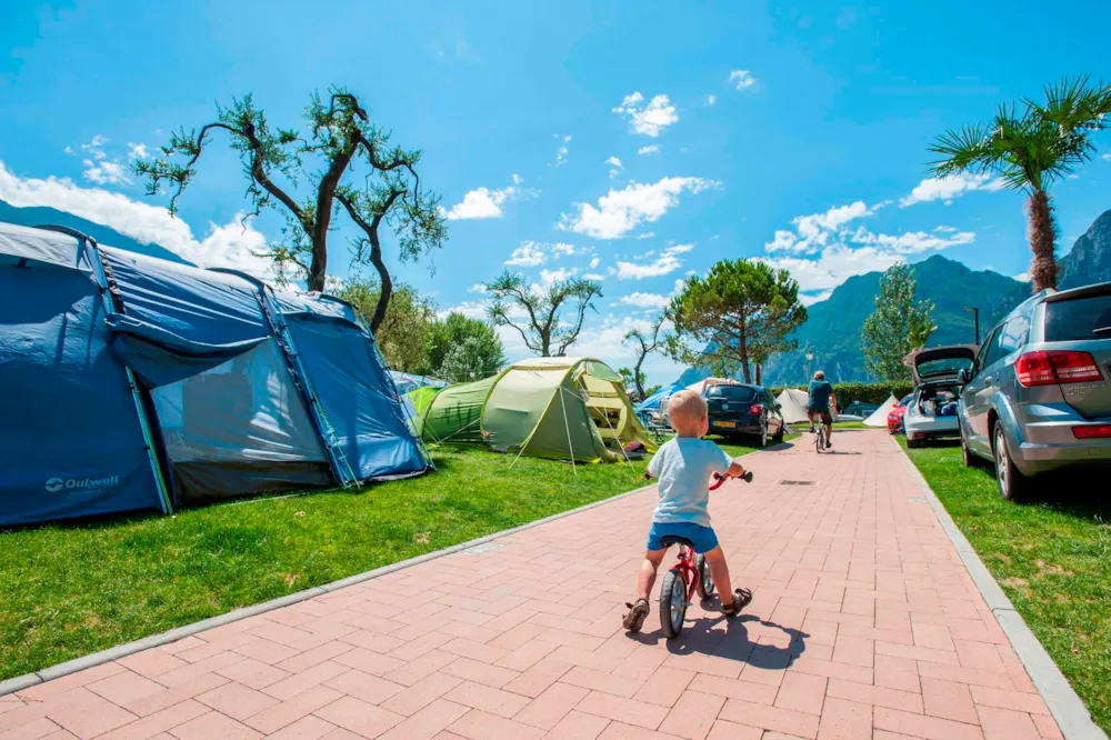 Kind fährt Rad zwischen Zelten und Campern