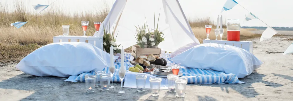 Romantisches Picknick mit weißem Zelt am Strand
