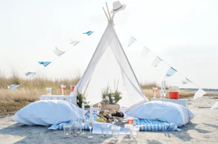 Romantisches Picknick mit weißem Zelt am Strand