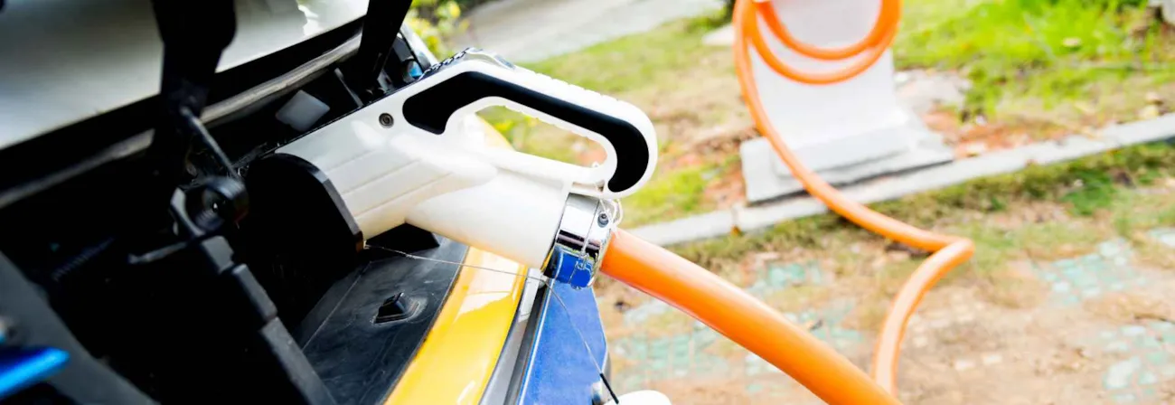 Nahaufnahme eines Elektroautos angeschlossen an eine Ladestation