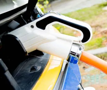 Nahaufnahme eines Elektroautos angeschlossen an eine Ladestation