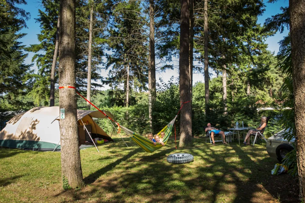 Familie auf Stellplatz mit Zelt und Hängematte