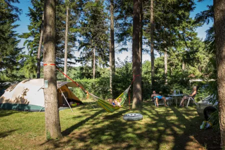 Familie auf Stellplatz mit Zelt und Hängematte