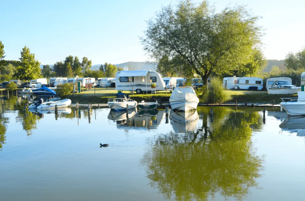 Campingplatz am See mit Booten an Anlegestelle