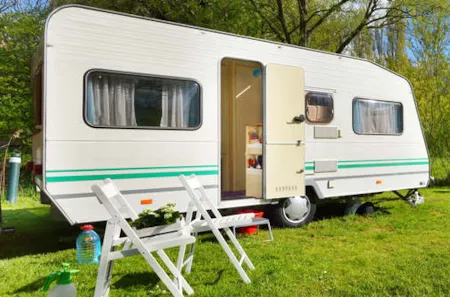Wohnwagen auf grüner Wiese an sonnigem Tag
