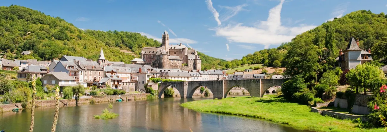 Blick auf den am Fluss gelegenen Ort Estaing im Aveyron in Okzitanien
