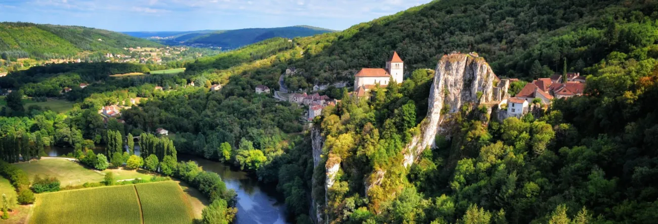 Blick auf den auf Felsen liegenden Ausflugsort Saint-Cirq-Lapopie am Ufer des Flusses Lot