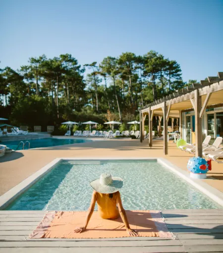 Vacancière se détendant au bord de la piscine d'un camping naturiste - Naturisme.fr