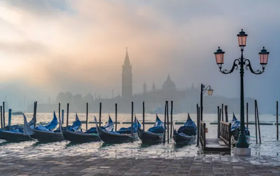 Gondeln in Venedig bei Sonnenaufgang im Morgennebel. Venetien, Italien.