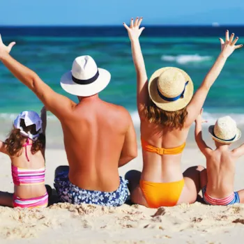 Rückenansicht einer Familie am Strand sitzend