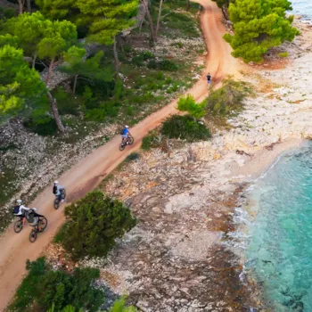 Luchtfoto van een onverhard fiets- en wandelpad met mountainbikers langs de Adriatische kust, Kroatië | Camping Direct