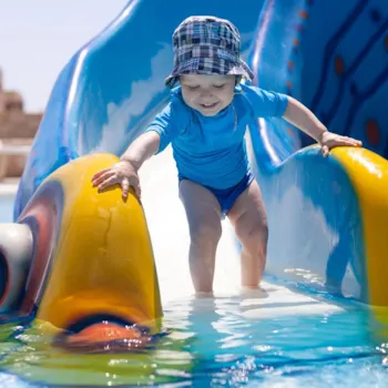 Kleine kind op waterglijbaan in een peuterbad van een camping