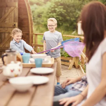 Familie mit Schulkindern auf einer Mobilheimterrasse beim Frühstück