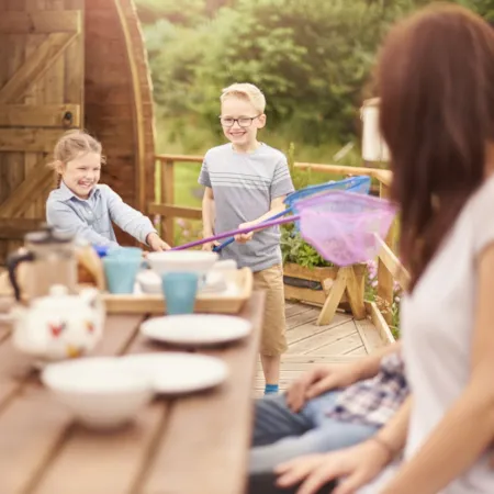 Familie mit Schulkindern auf einer Mobilheimterrasse beim Frühstück