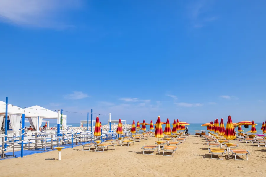 Blick auf den Strand von Cavallino-Treporti (Venetien, Italien) mit blauem Himmel und Sonnenschirmen