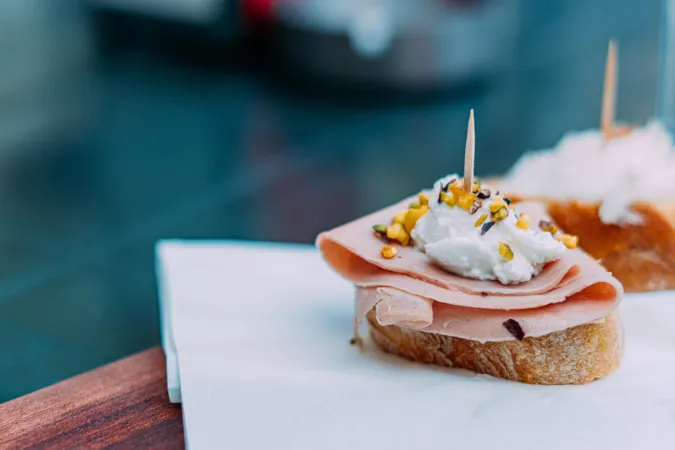Nahaufnahme eines venezianischen Cicchetti mit Mortadella, Baccalà Mantecato und Pistazien in Venedig, Italien