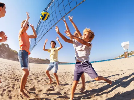 Kinder spielen Beachvolleyball am Strand