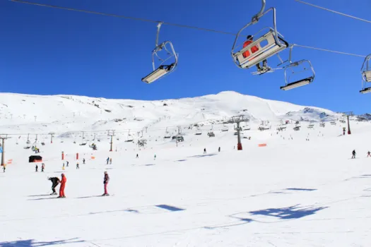Blick auf eine belebte Skipiste in der Sierra Nevada, nahe Granada, Spanien