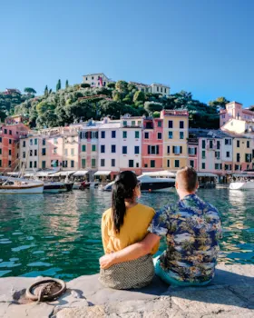 
Junges Touristenpaar von hinten, sich umarmend, am Hafen von Portofino, Italien
