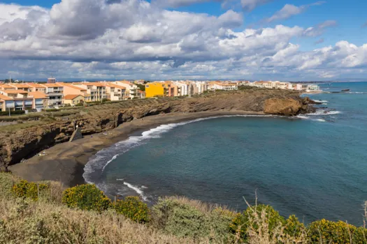 Blick auf den aus Basaltgestein bestehende Strand Grande-Conque an einem bewölkten Tag in Cap d'Agde, Frankreich
