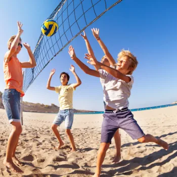 Kinder spielen Beachvolleyball am Strand