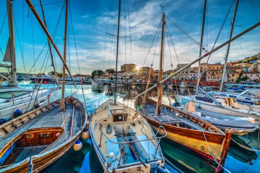 Holzboote im Hafen von La Maddalena bei Sonnenuntergang auf Sardinien, Italien