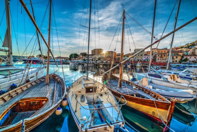 Holzboote im Hafen von La Maddalena bei Sonnenuntergang auf Sardinien, Italien
