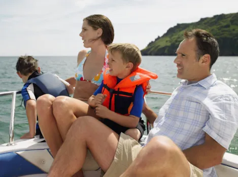 Familie mit kleinen Kindern in Schwimmweste auf einem Boot