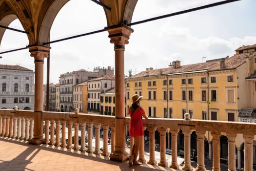 Padua – Eine Touristin genießt den Blick auf die Piazza delle Erbe von der Loggia des Palazzo della Ragione in Padua, Venetien, Italien