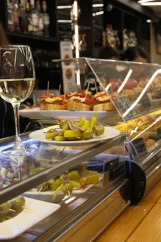 Blick auf die Theke einer typischen spanischen Tapasbar mit Weinglas und Pintxos
