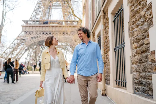 Ein junges Paar spaziert vor dem Eiffelturm in Paris, Frankreich